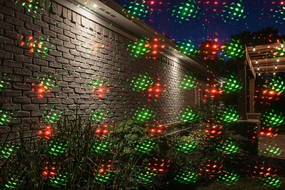 lazerio šviesos projekcija ant namo sienos sodo